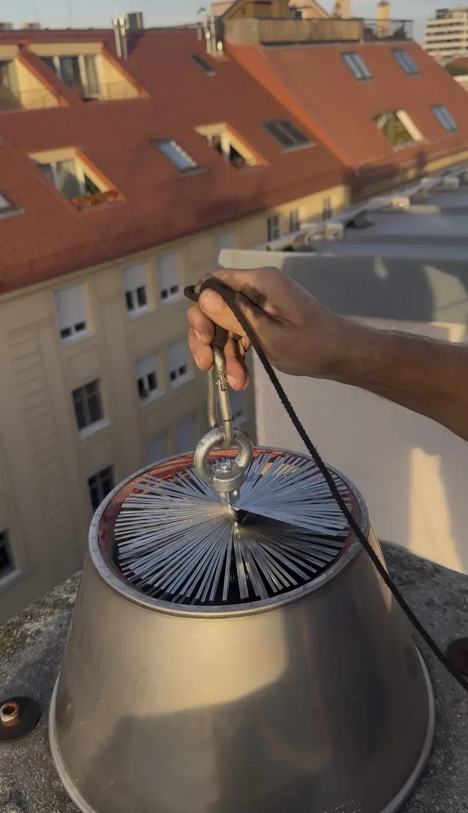 Čistenie komína v meste nad strechami