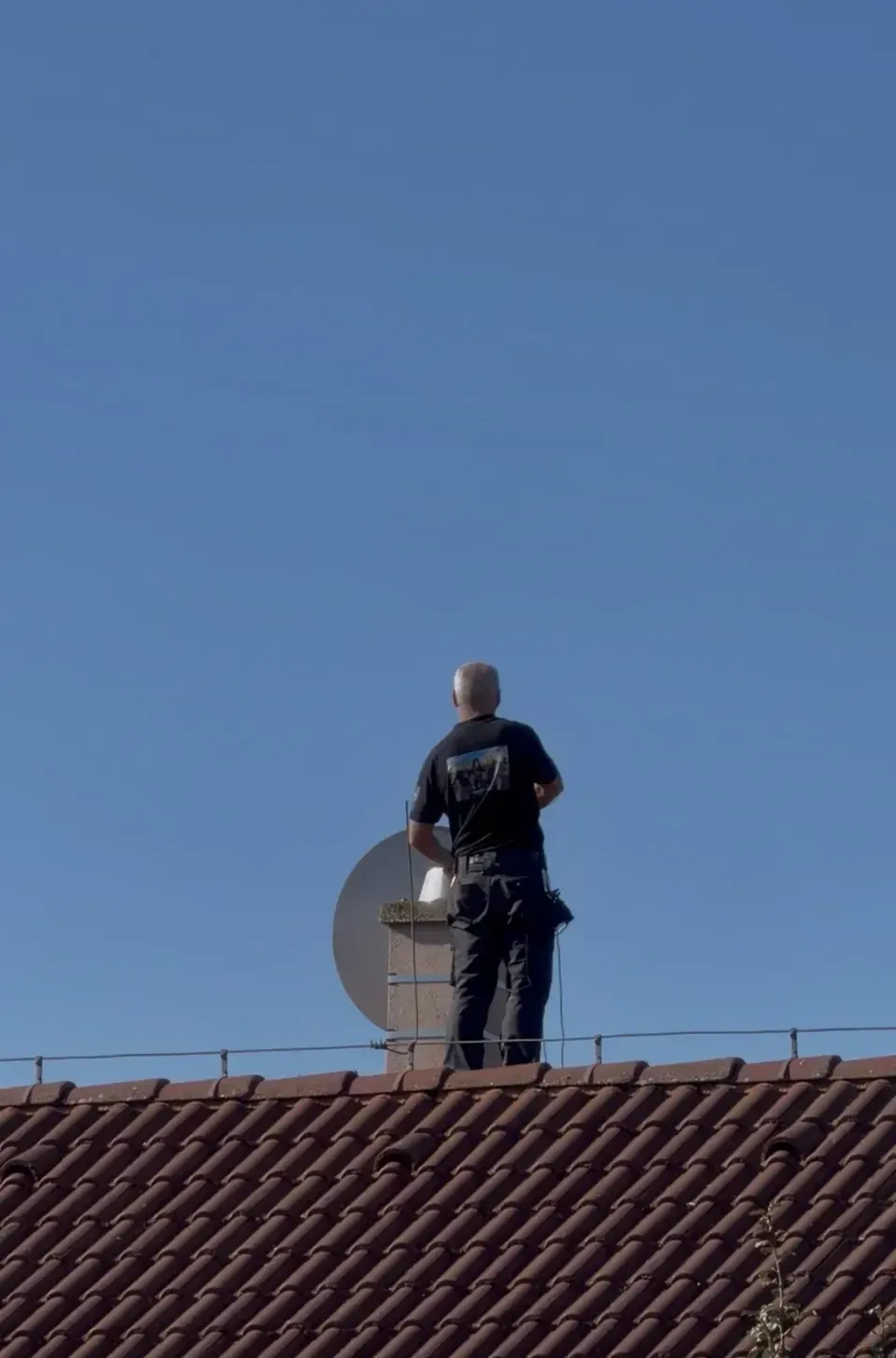 Kominár pri práci na šikmej streche